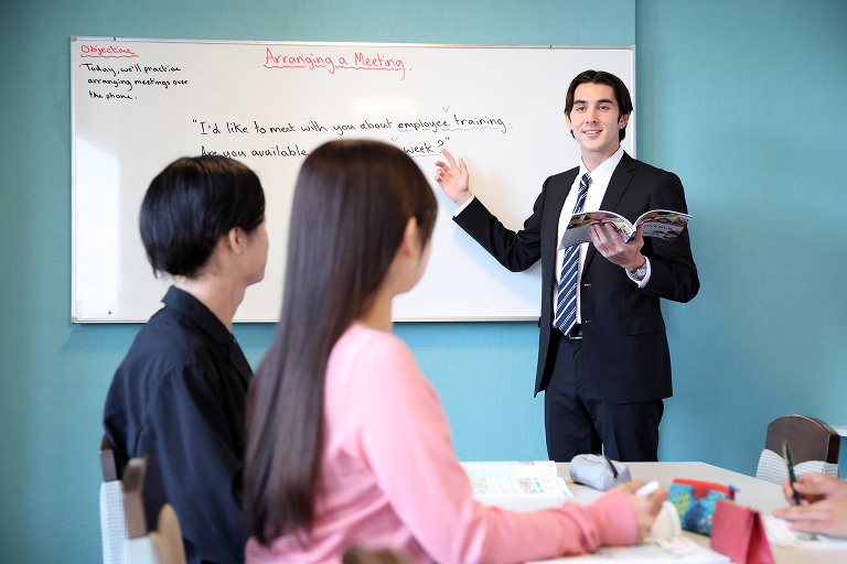 外国人教師に指導を受ける生徒の画像